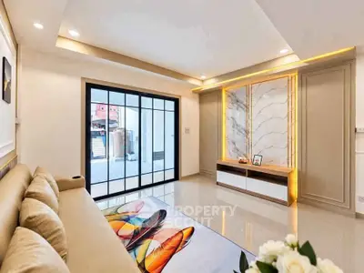 Modern living room with elegant marble feature wall and large sliding glass doors.