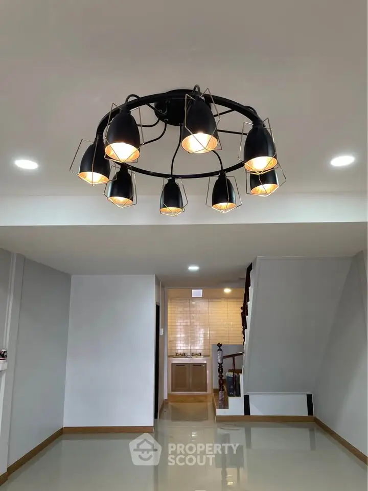 Modern living room with stylish chandelier and glossy flooring