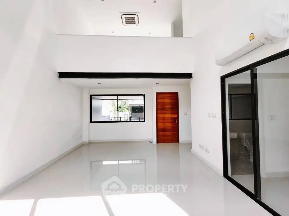 Spacious modern living room with high ceiling and large windows for natural light