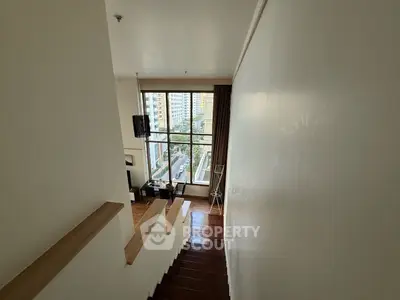 Spacious loft with large window offering stunning city views, perfect for modern urban living.