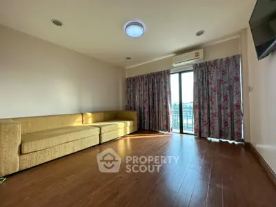 Spacious living room with large windows and modern sofa in a bright apartment.