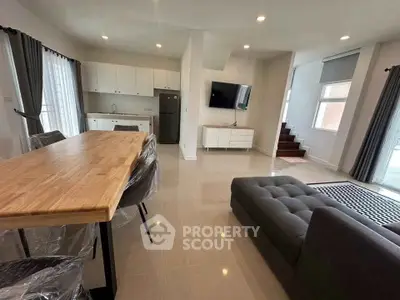 Spacious modern living room with open kitchen and stylish furniture in a bright, airy setting.