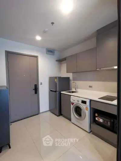 Modern kitchen with sleek appliances and compact design in a stylish apartment.