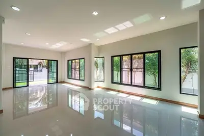 Spacious modern living room with large windows and glossy tile flooring