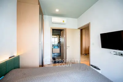 Modern bedroom with ensuite bathroom and wall-mounted TV in stylish apartment.