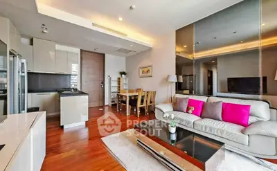 Modern living room with open kitchen, stylish decor, and hardwood floors in a contemporary apartment.