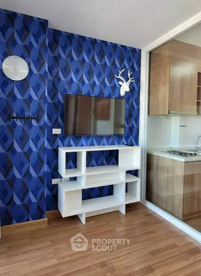 Modern living room with stylish blue geometric wallpaper and sleek white TV stand