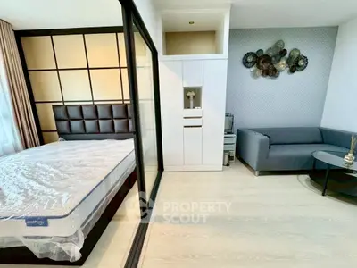 Modern bedroom with stylish decor and cozy seating area, featuring a sleek design and ample natural light.