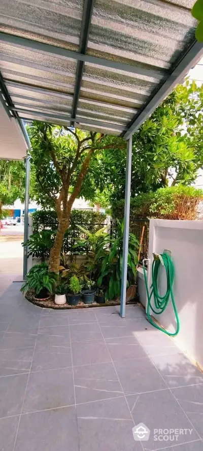 Charming garden patio with lush greenery and modern tiled flooring