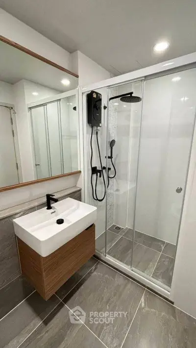 Modern bathroom with sleek shower and stylish vanity in contemporary apartment.