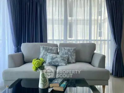 Elegant living room with plush sofa and floor-to-ceiling windows for natural light.