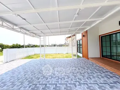 Spacious covered patio with modern tile flooring and garden view