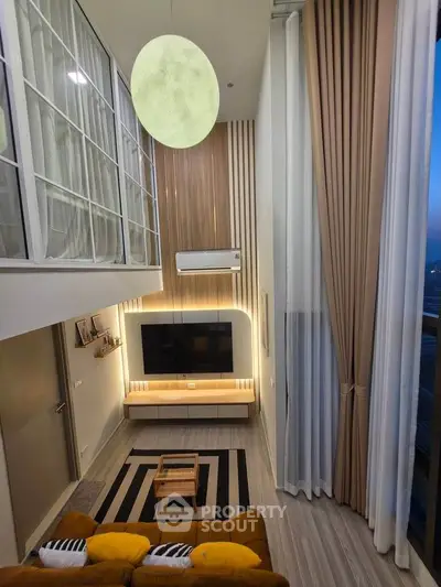 Modern high-ceiling living room with stylish decor and large windows.