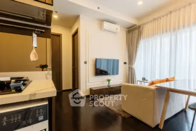 Modern living room with open kitchen, featuring sleek design and natural light.