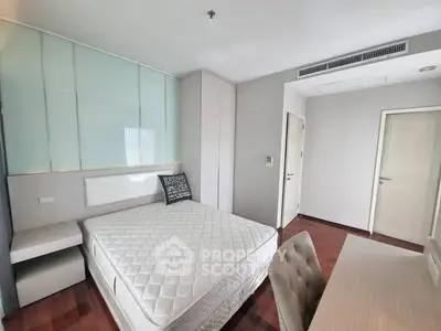 Modern bedroom with stylish decor and hardwood floors in a contemporary apartment.