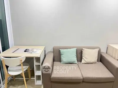 Cozy living room with modern sofa and compact dining area, perfect for urban living.