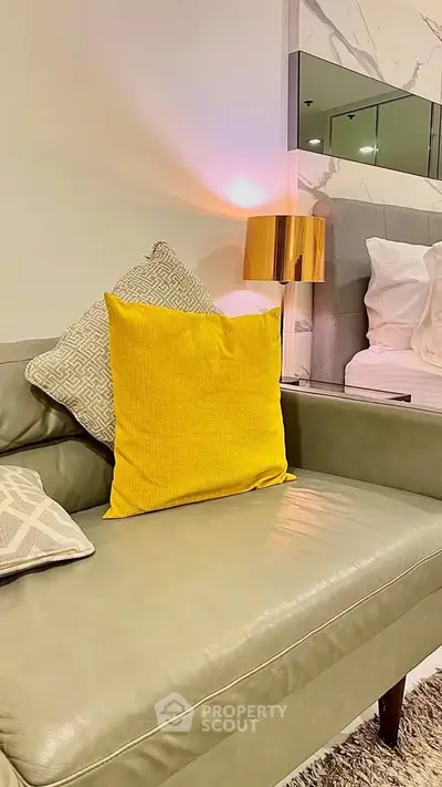 Modern living room with stylish sofa and vibrant yellow cushion, elegant decor for a cozy ambiance.