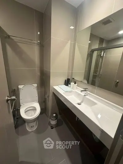 Modern bathroom with sleek fixtures and spacious vanity in contemporary apartment.