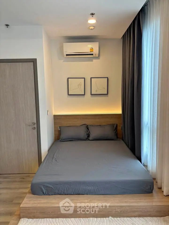 Modern bedroom with sleek design, featuring a cozy bed, stylish decor, and natural light from large windows.