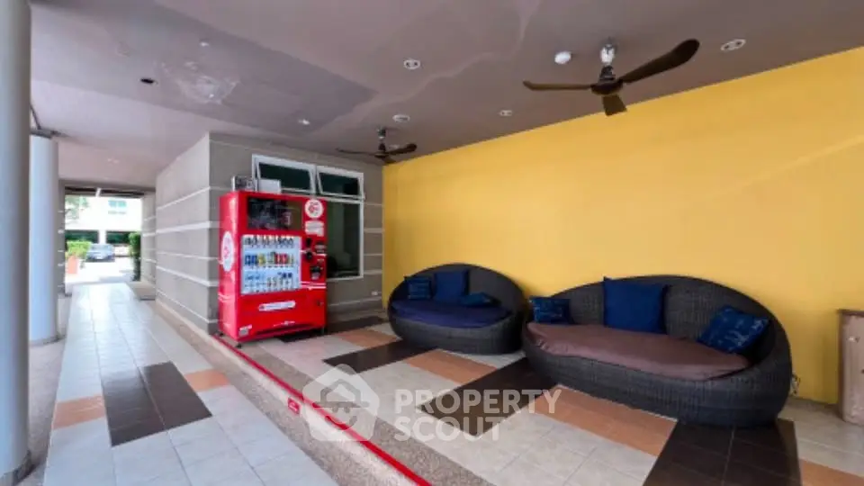 Stylish outdoor seating area with vending machine in modern building lobby.