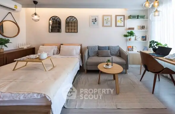 Chic studio apartment with cozy bed, stylish sofa, and modern decor in open layout.