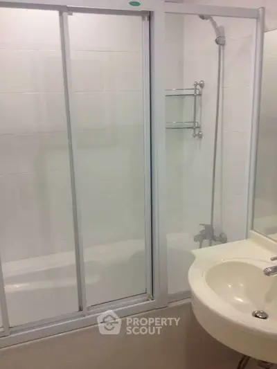 Modern bathroom with sleek shower enclosure and elegant sink design.