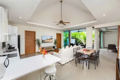 Spacious open-plan living room with modern kitchen and lush garden view.
