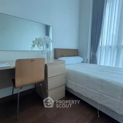 Cozy bedroom with modern furniture and large window for natural light.