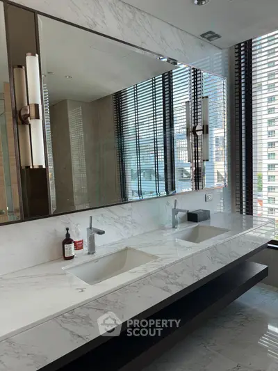 Luxurious modern bathroom with dual sinks and marble countertops in high-rise apartment.