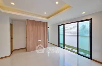 Spacious modern living room with large windows and elegant ceiling lights