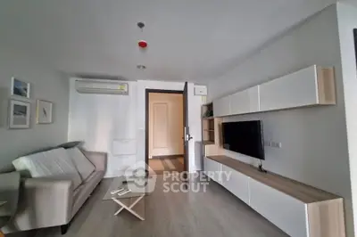 Modern living room with sleek furniture and wall-mounted TV in a stylish apartment.
