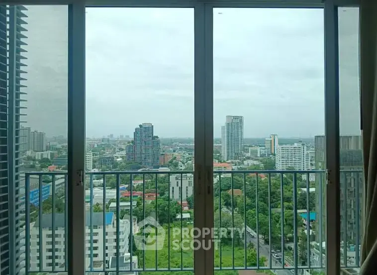 Stunning cityscape view from high-rise balcony with expansive skyline and lush greenery.