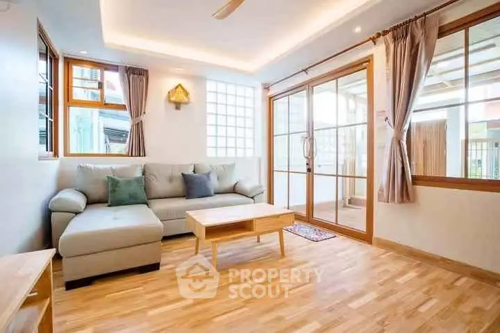 Bright and spacious living room with modern decor and large windows.