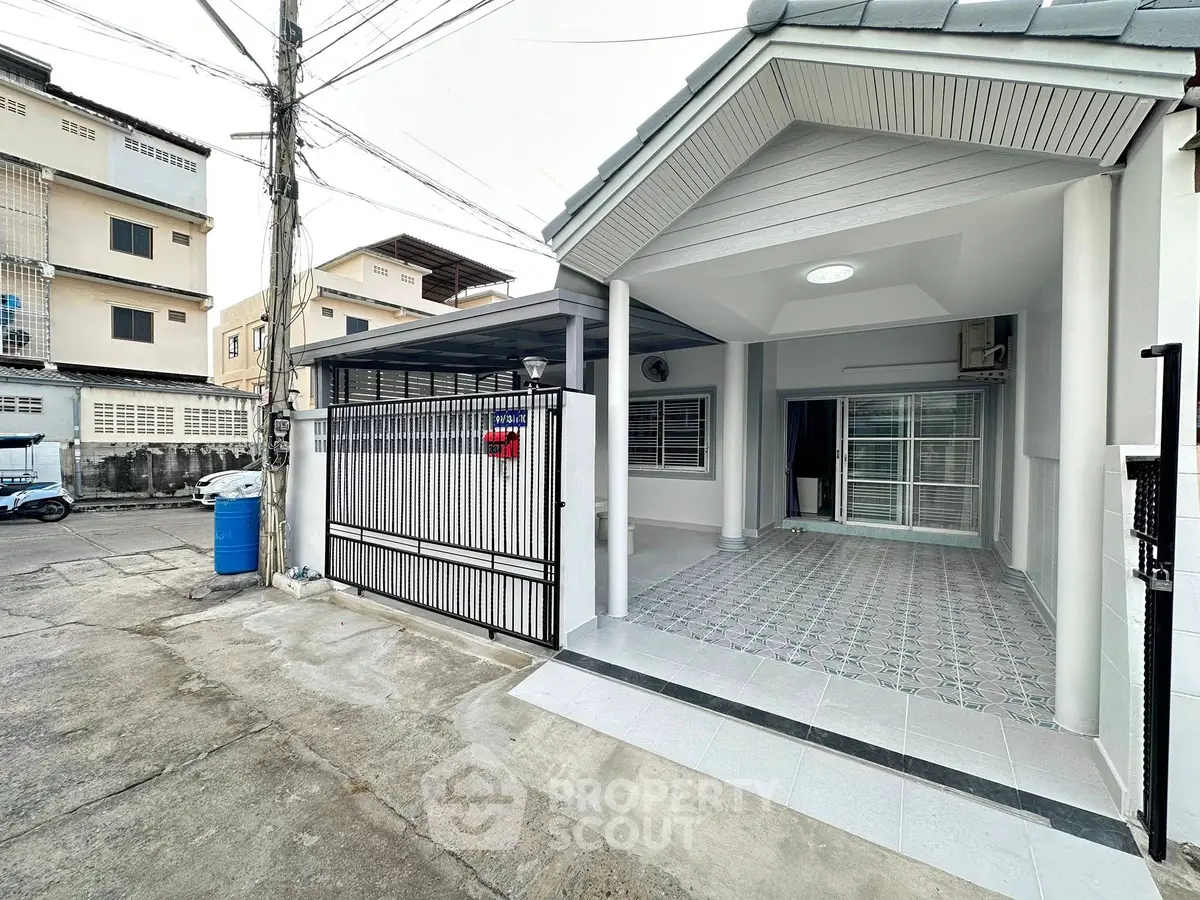 Charming single-story home with gated entrance and covered patio in urban setting.