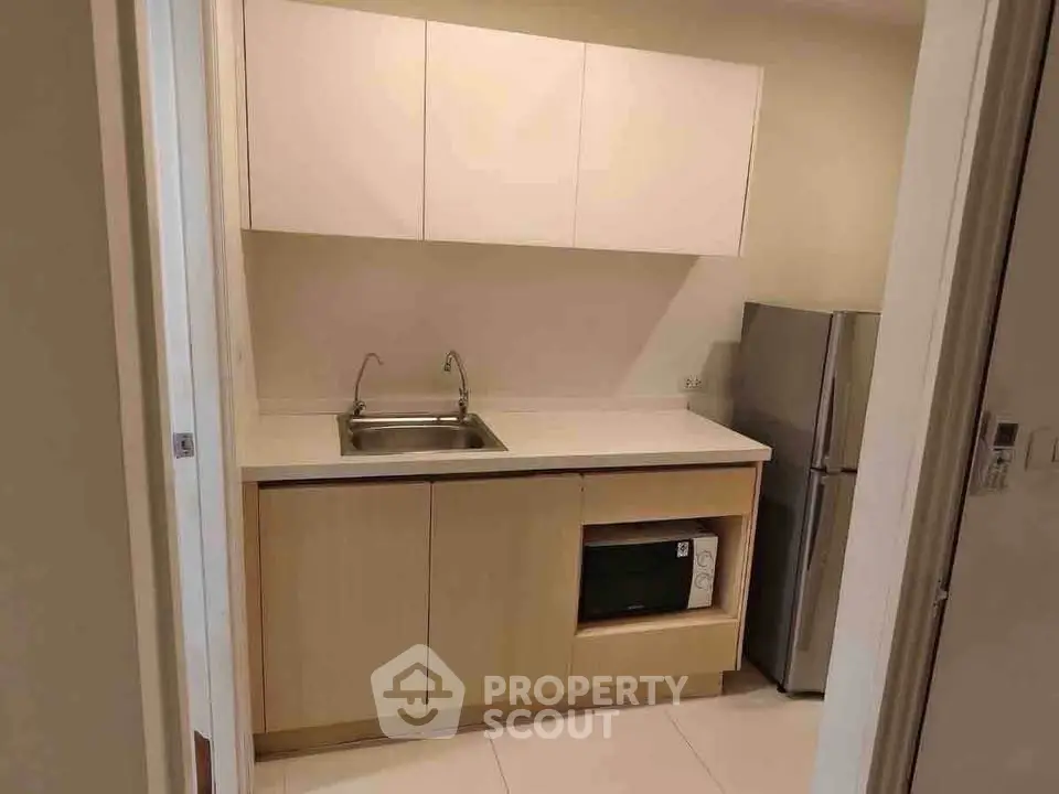 Modern compact kitchen with sleek cabinetry and stainless steel appliances.