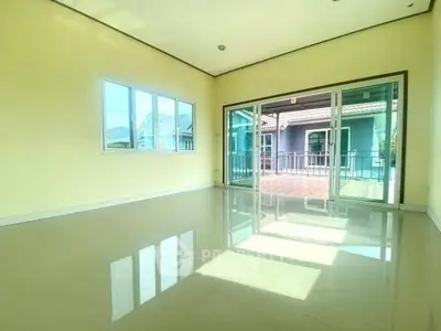 Spacious living room with large windows and sliding doors to balcony