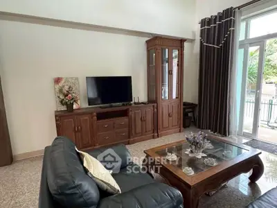 Spacious living room with elegant wooden furniture and large windows for natural light.