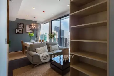 Modern living room with dining area and city view from balcony, featuring elegant decor and ample natural light.