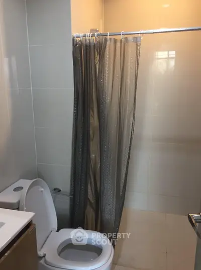 Modern bathroom with sleek design and shower curtain in a contemporary apartment.