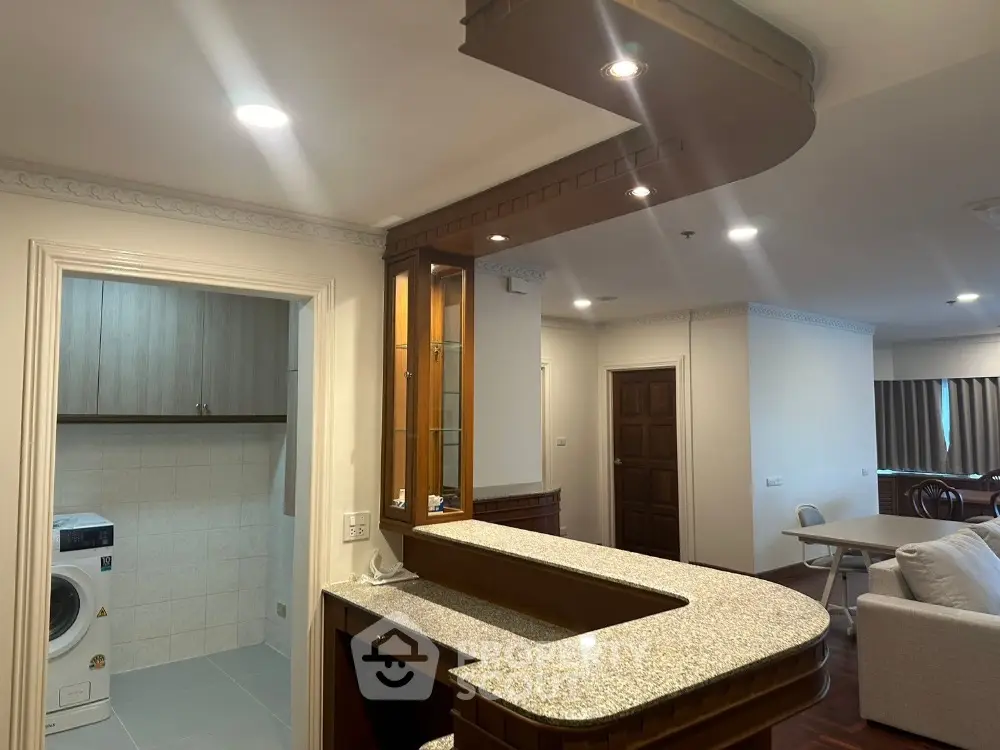 Spacious open-plan living area with modern kitchen and laundry facilities