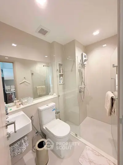 Modern bathroom with glass shower and sleek fixtures in contemporary apartment