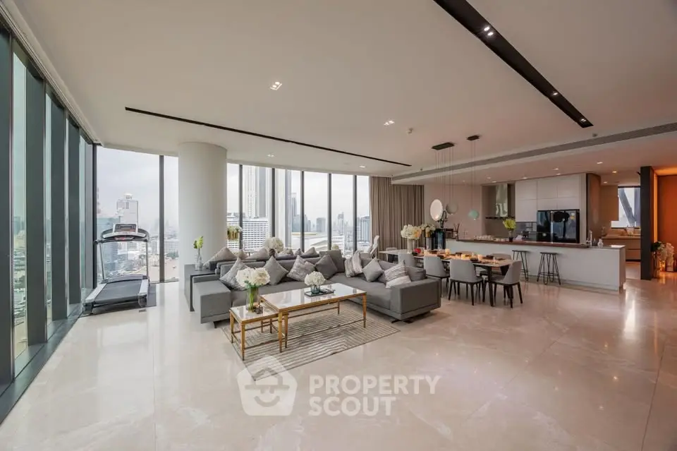 Luxurious open-plan living room with stunning city views and modern kitchen in high-rise apartment.