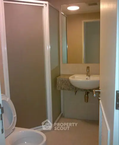 Compact modern bathroom with shower and sleek fixtures in a contemporary apartment.