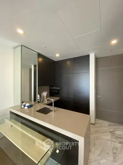 Modern kitchen with sleek cabinetry and built-in oven in luxury apartment.