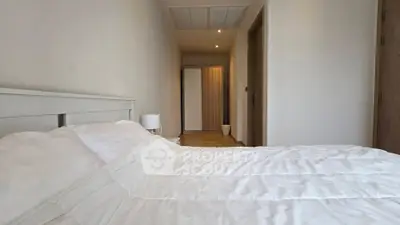 Spacious bedroom with cozy white bedding and modern wardrobe in a minimalist design.