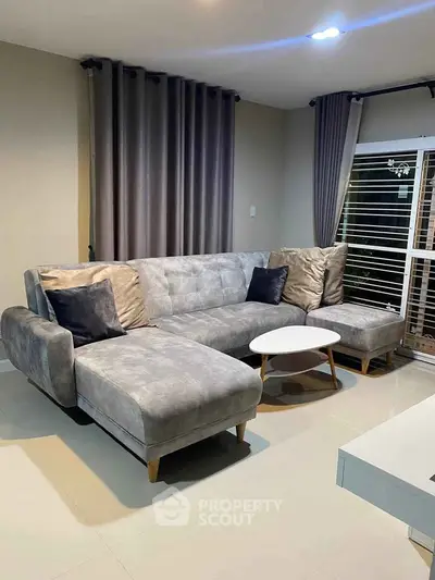 Modern living room with stylish gray sectional sofa and elegant curtains