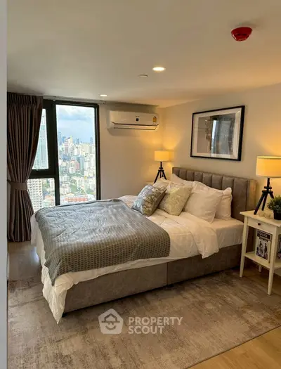 Luxurious bedroom with city view, modern decor, and cozy ambiance in high-rise apartment.