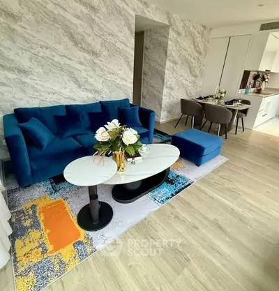 Stylish modern living room with blue sofa and elegant dining area