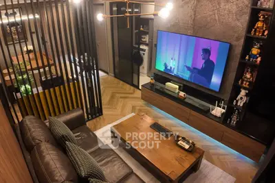 Modern living room with stylish decor and large TV, featuring a cozy seating area and elegant lighting.