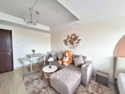 Cozy living room with plush sofa and elegant chandelier, perfect for relaxation.